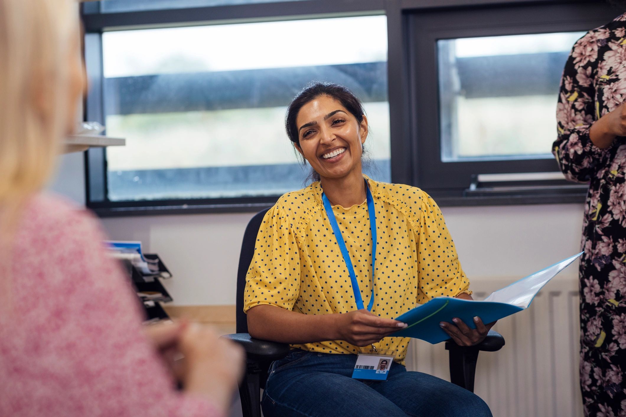 Teacher smiling while holding papers