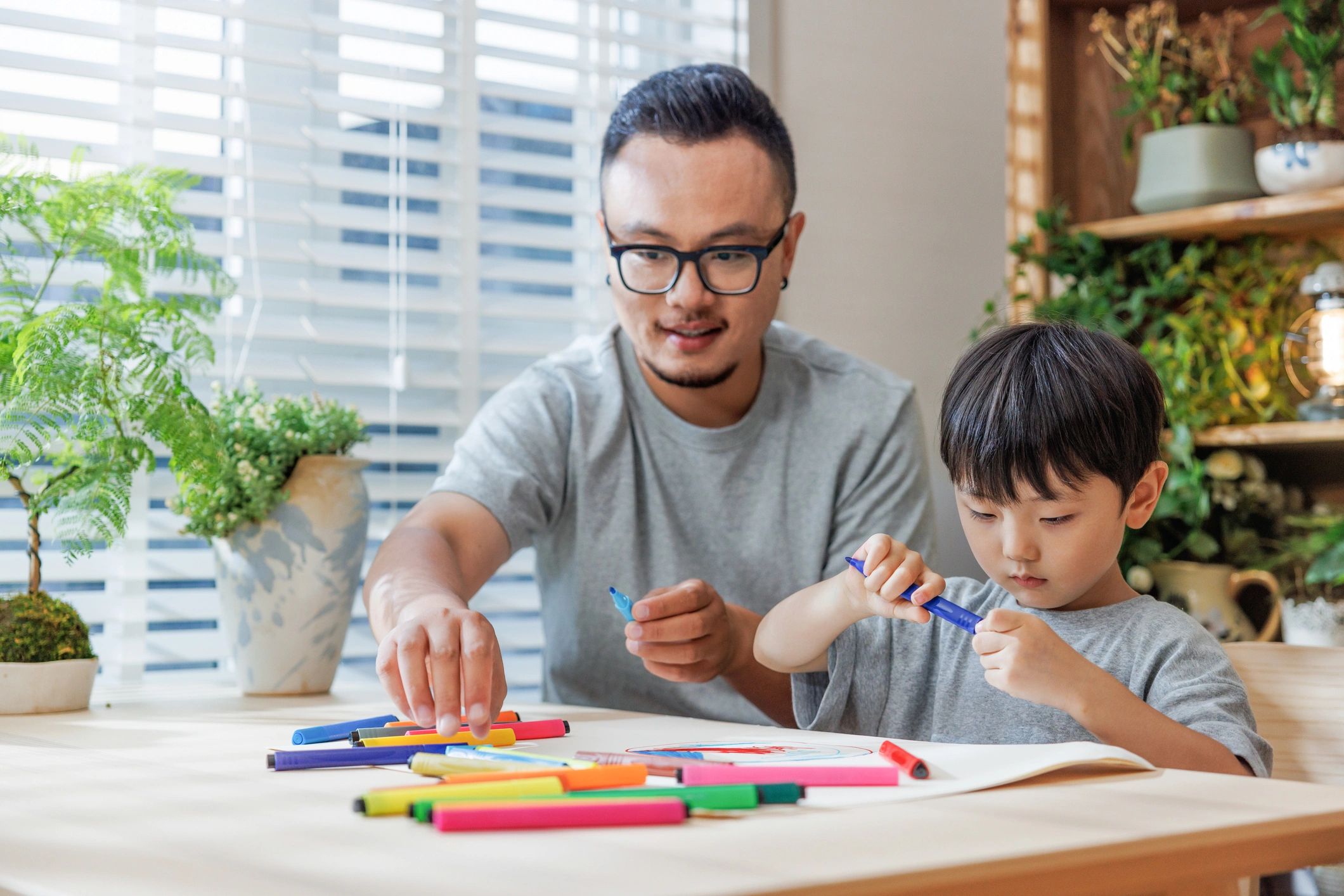 Parent and child coloring together at a table
